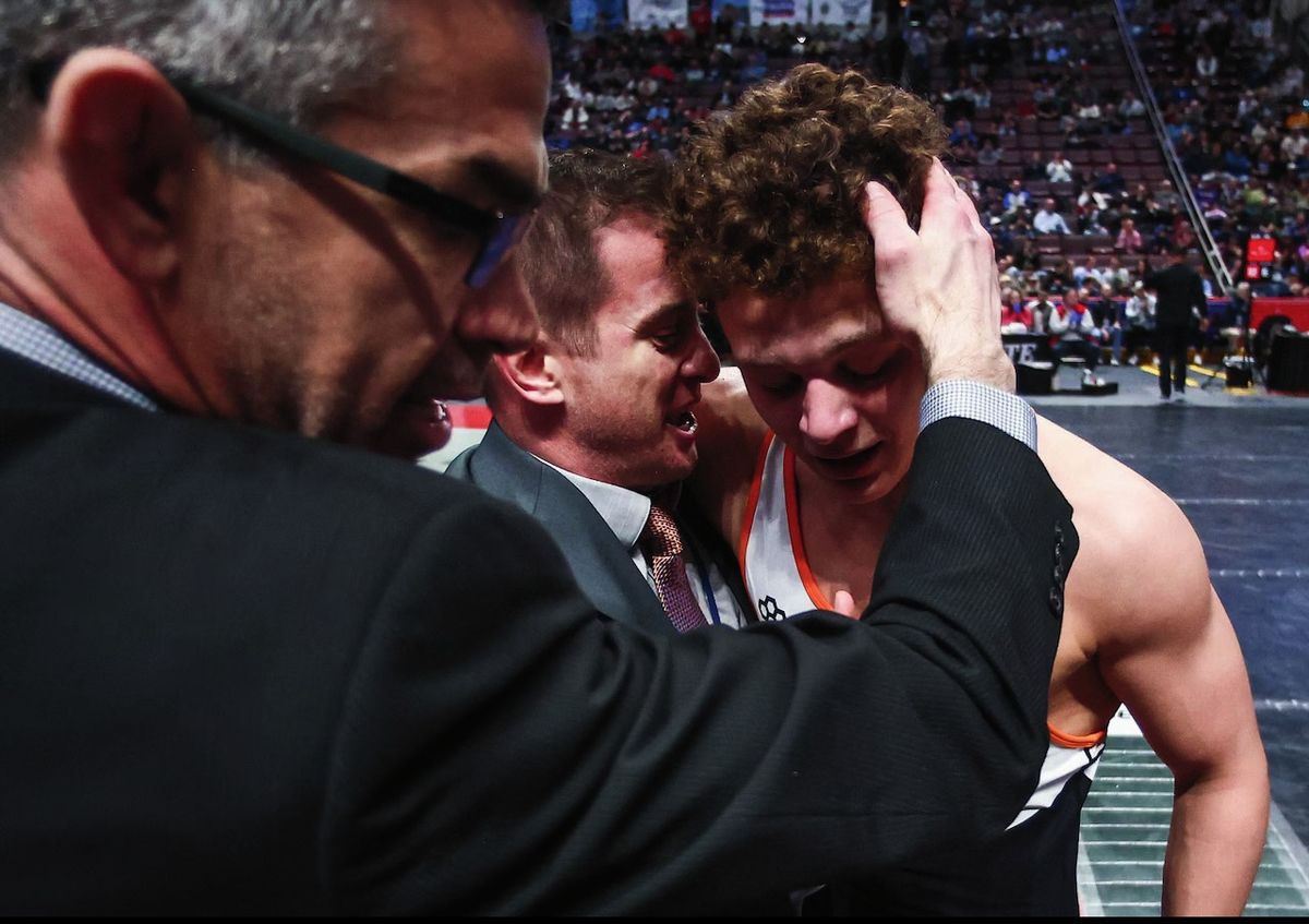 Coaches embrace Gabe Ballard after a win
