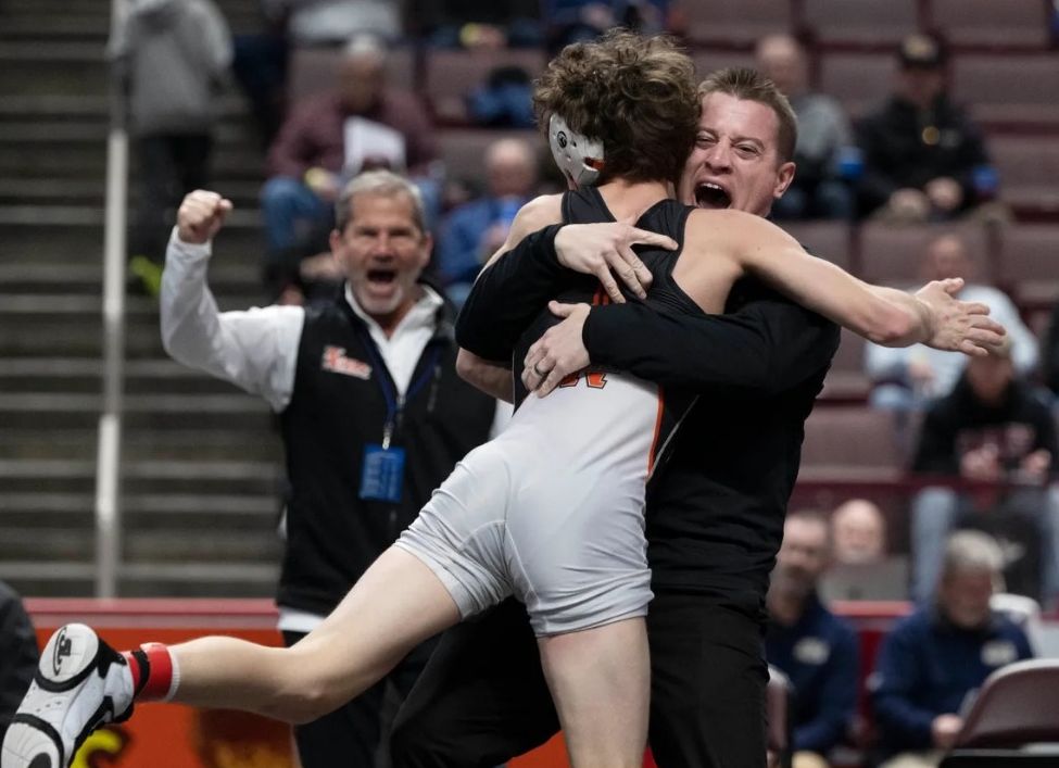 Carson Wagner leaps into his coach’s arms after winning his state semifinal