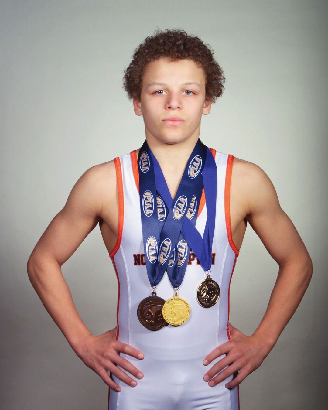 Gabe Ballard in a white Northampton singlet wearing his postseason medals