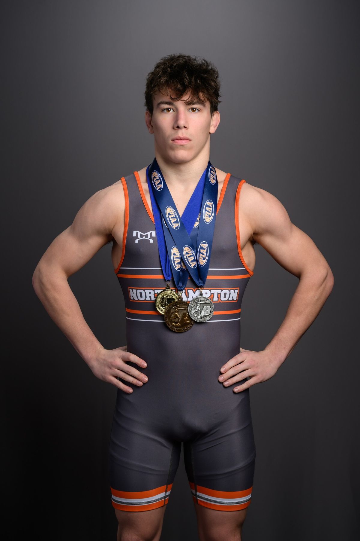 Trey Wagner in a gray Northampton singlet wearing his postseason medals