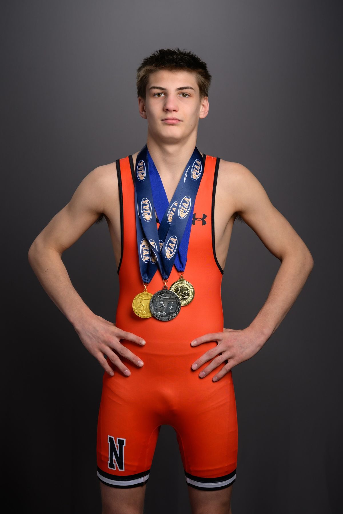 Brayden Wenrich in an orange Northampton singlet wearing his postseason medals