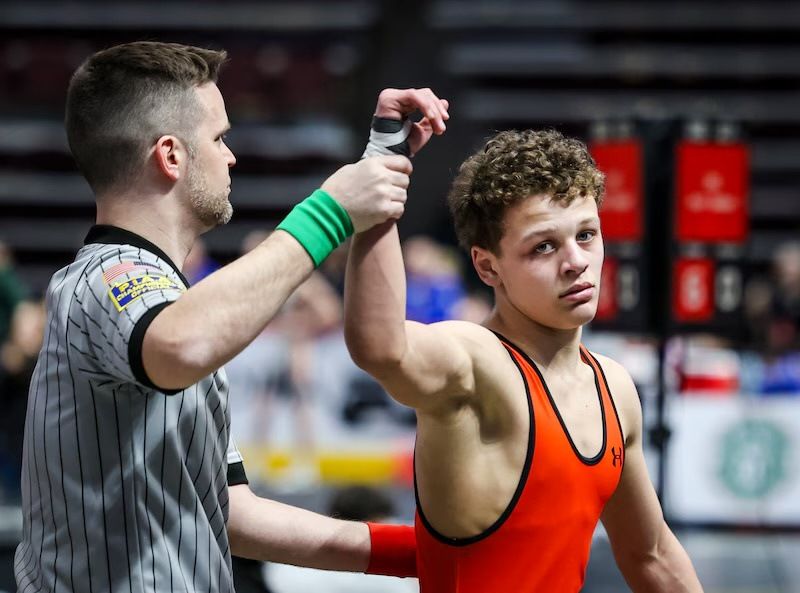 A Northampton wrestler in orange has his hand raised